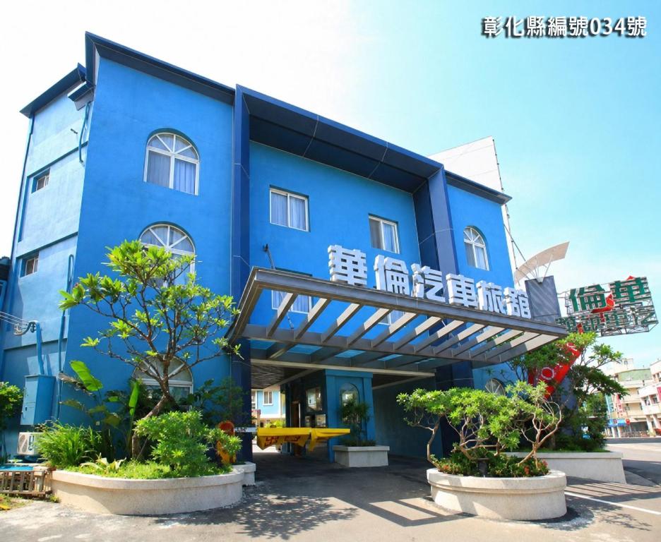 a blue building with a balcony and some trees at 華倫汽車旅館 in Erlin
