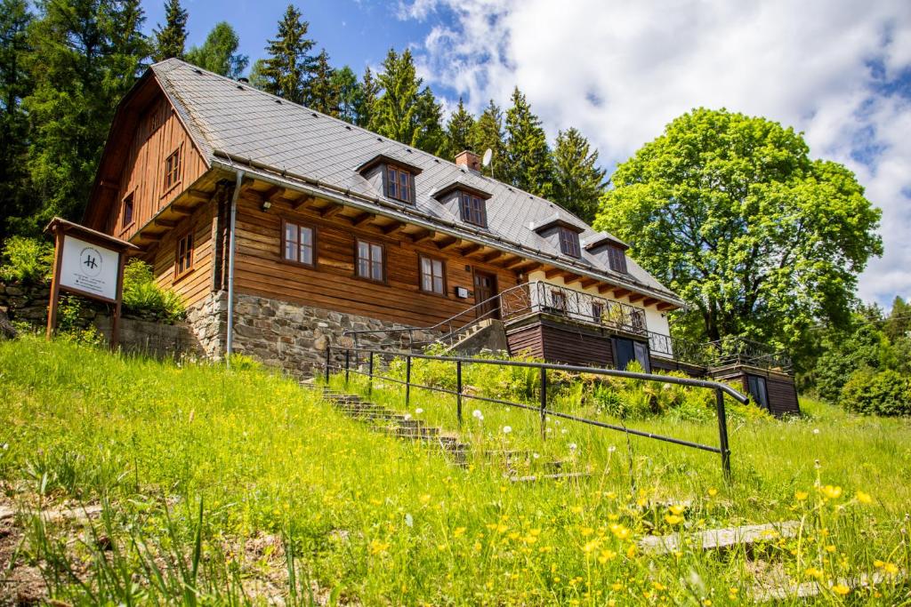 an old wooden house on a hill with a grass field at Chata Svahovka in Malá Morávka