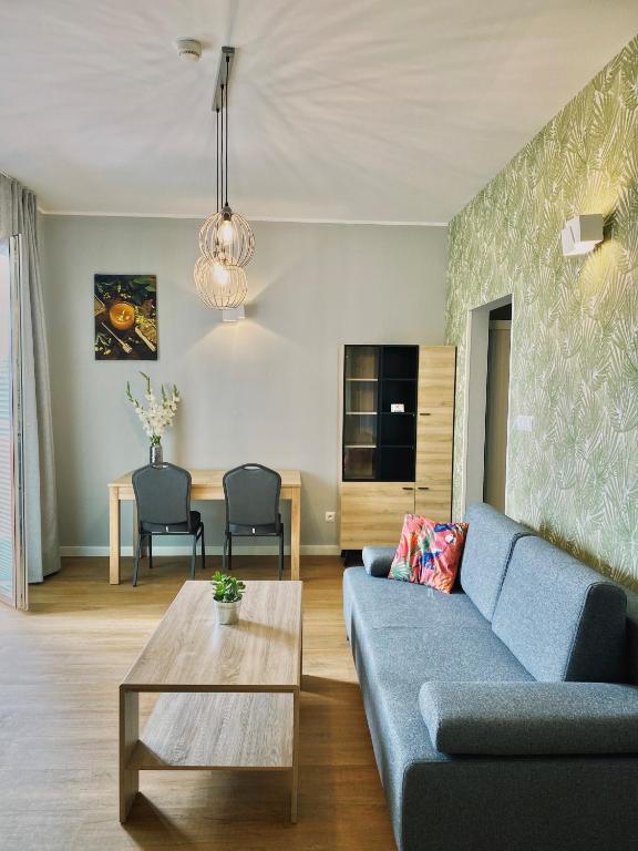 a living room with a blue couch and a table at Apartamenty 107 in Rumia