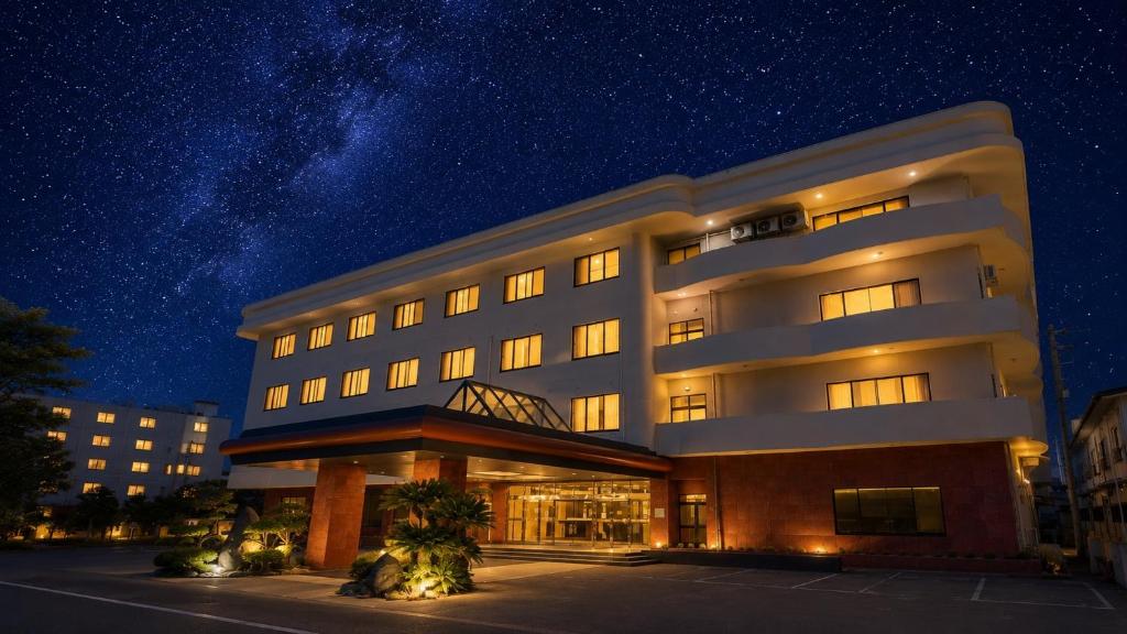 ein großes Gebäude mit einem Sternenhimmel im Hintergrund in der Unterkunft Livemax Resort Isawa Onsen in Fuefuki