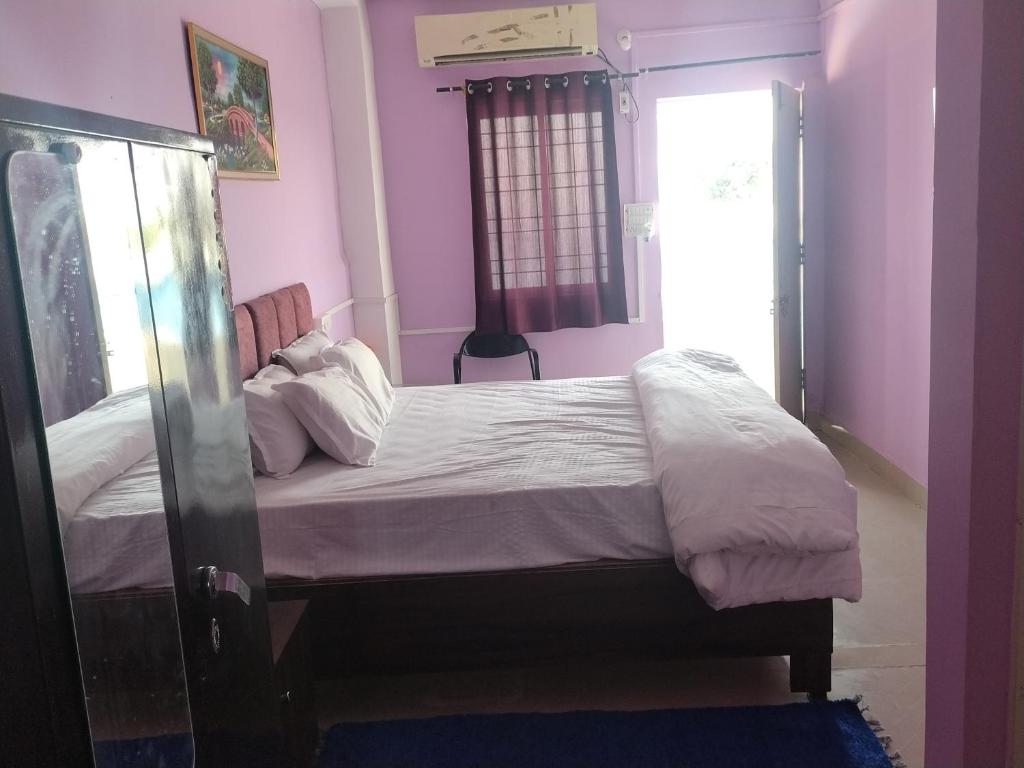 a bedroom with a bed and a window at Hotel madhav regency bhopal in Misrod