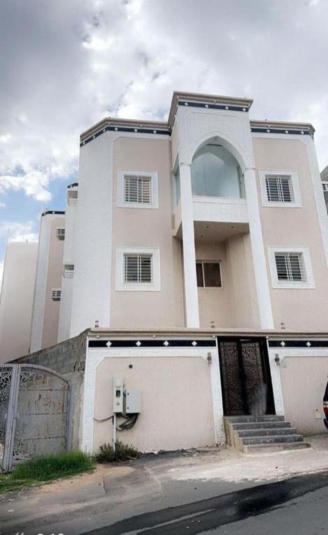 a large white house with a fence in front of it at شقة فاخرة بغرفتين نوم وصالة ومجلس in Abha