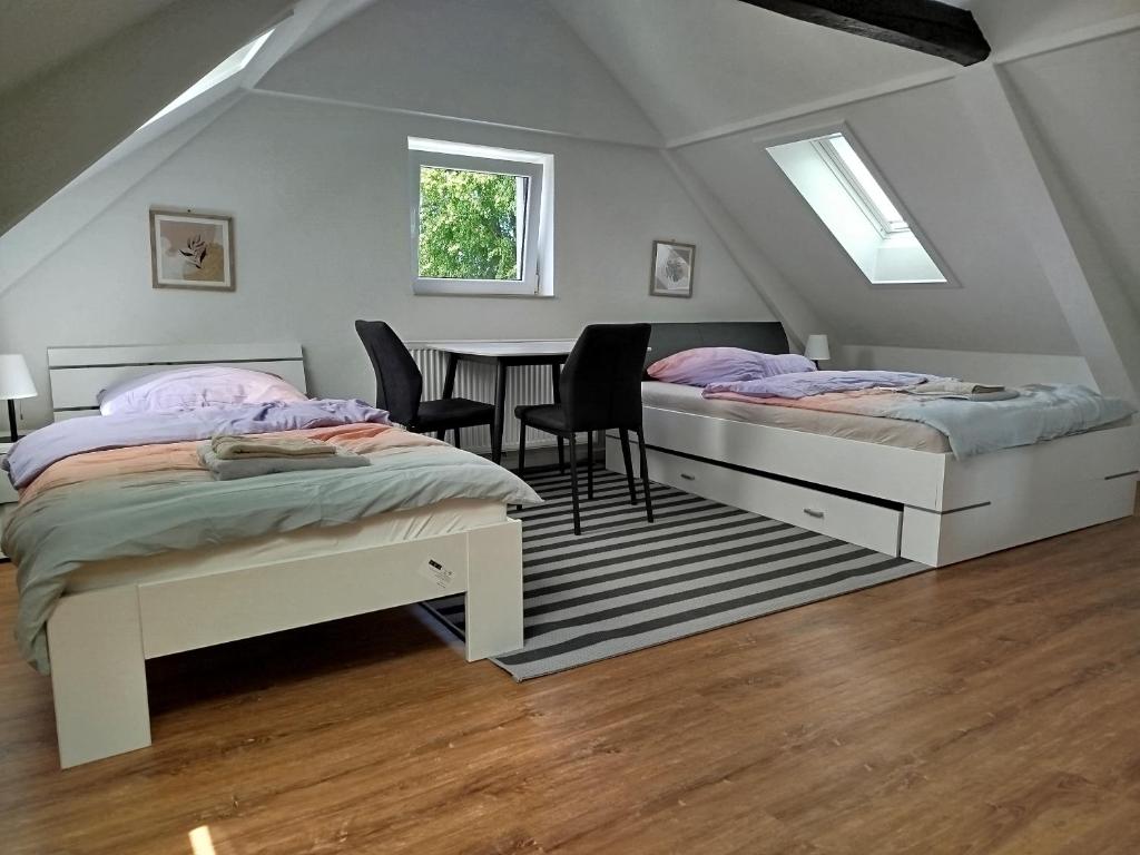 two beds in a room with a table and chairs at Ferienwohnung Schießstatt in Bad Saulgau
