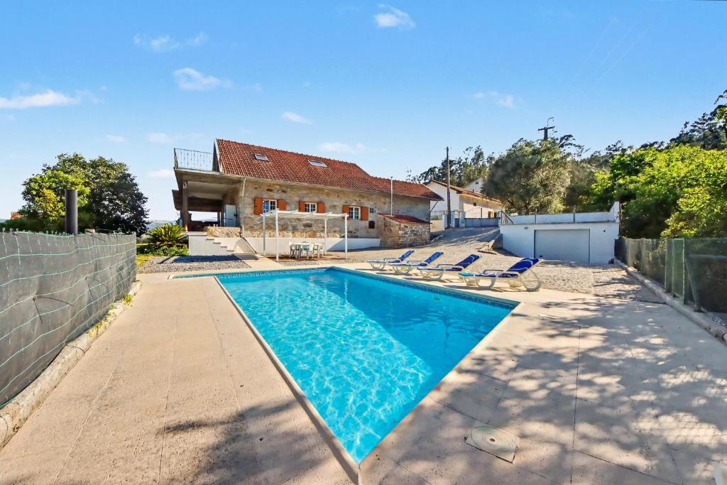 a swimming pool in front of a house at Casa Na Aldeia in Arões