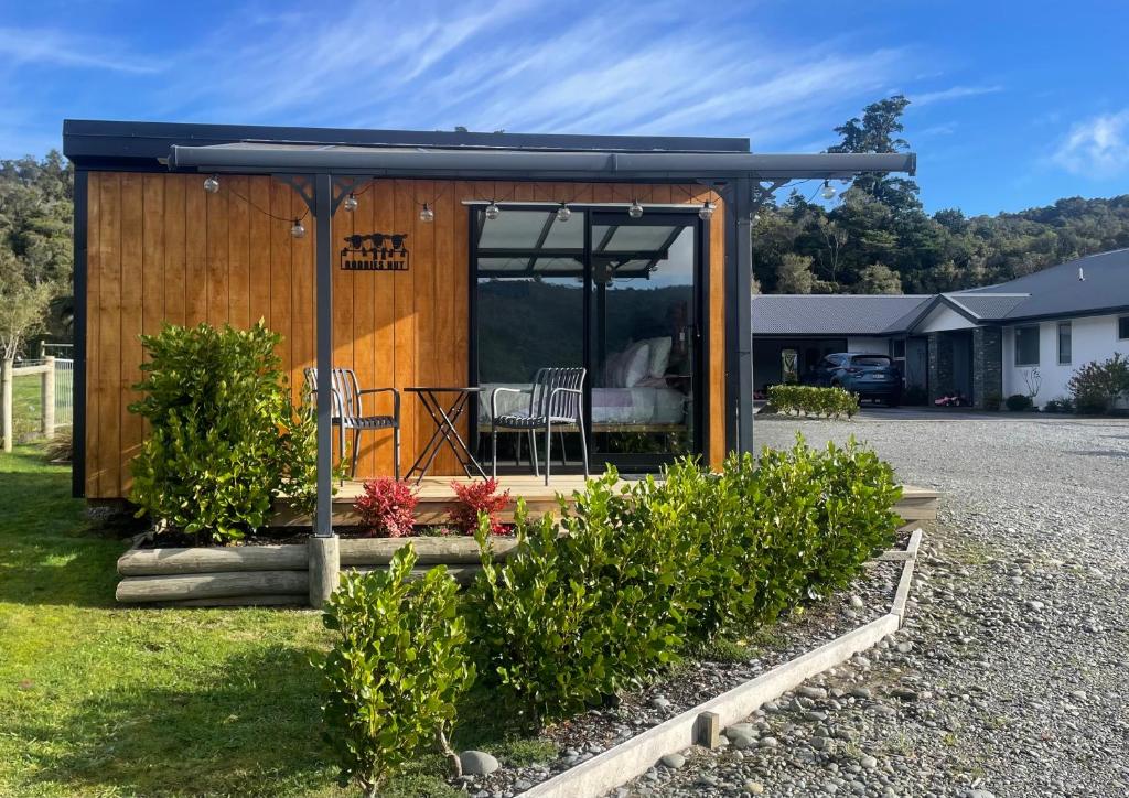 a wooden shed with a table and chairs in it at Robbies Hut in Greymouth