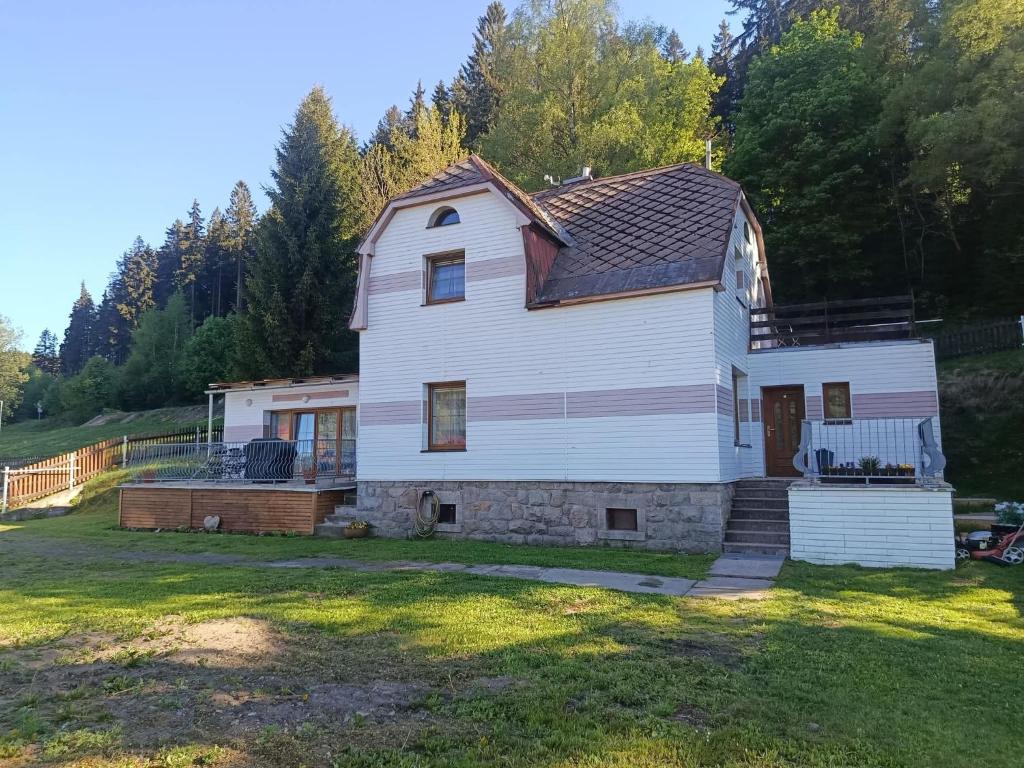 a house in a yard with trees in the background at Apartmány 86 in Potŭčky