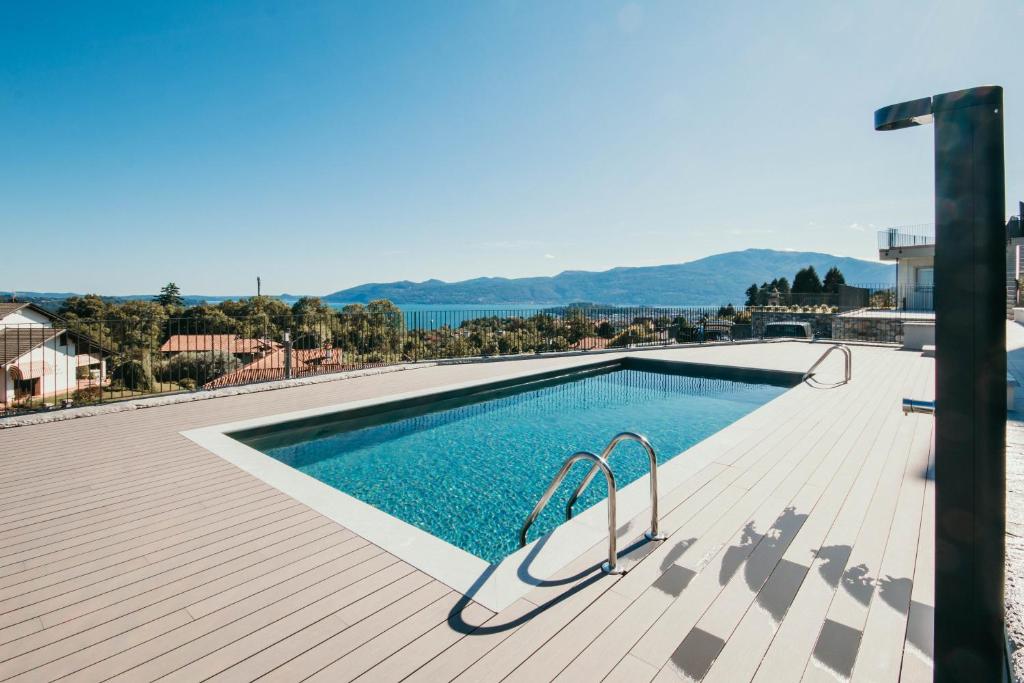 a swimming pool on a wooden deck next to a building at Appartamento Meda - Lakeside Leisure & Business in Cissano