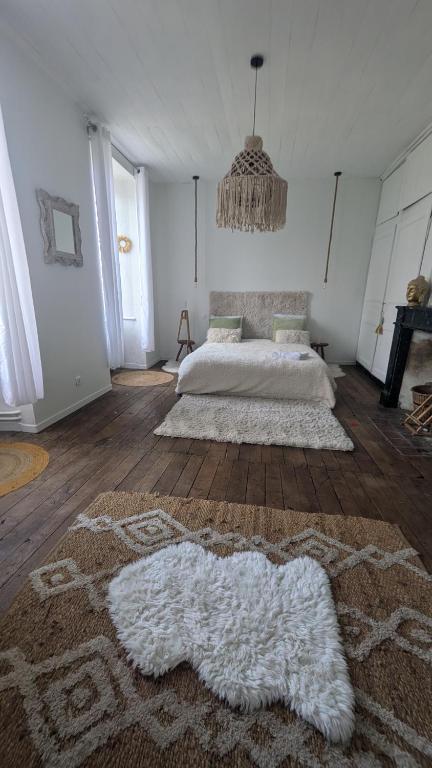 a bedroom with a bed and a large rug at L'héritage in Champdeniers