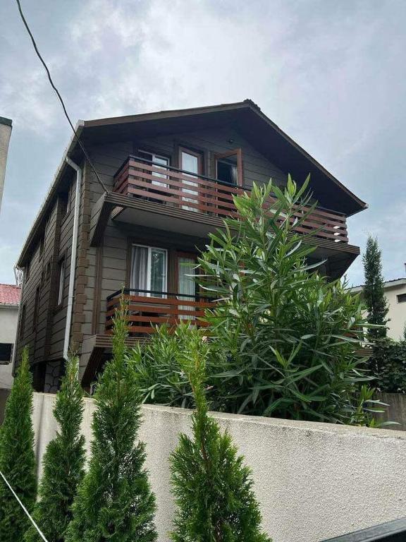 a house with a balcony on top of a fence at Guesthouse Sunshine Ureki in Ureki