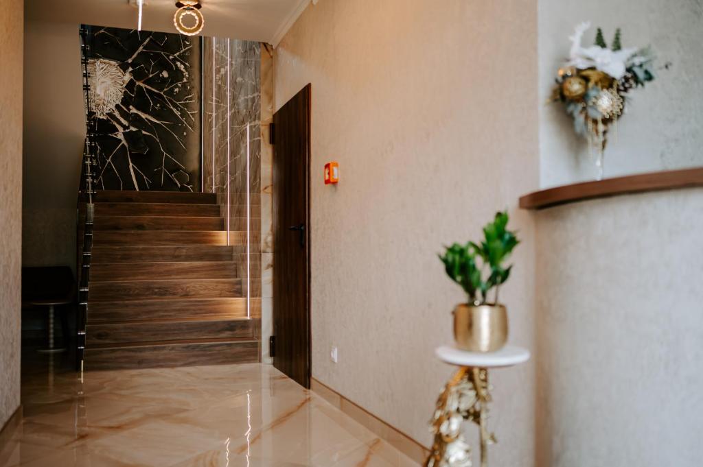 a hallway with a door and a staircase with a potted plant at Diamond Boutique Hotel in Pruszcz Gdański