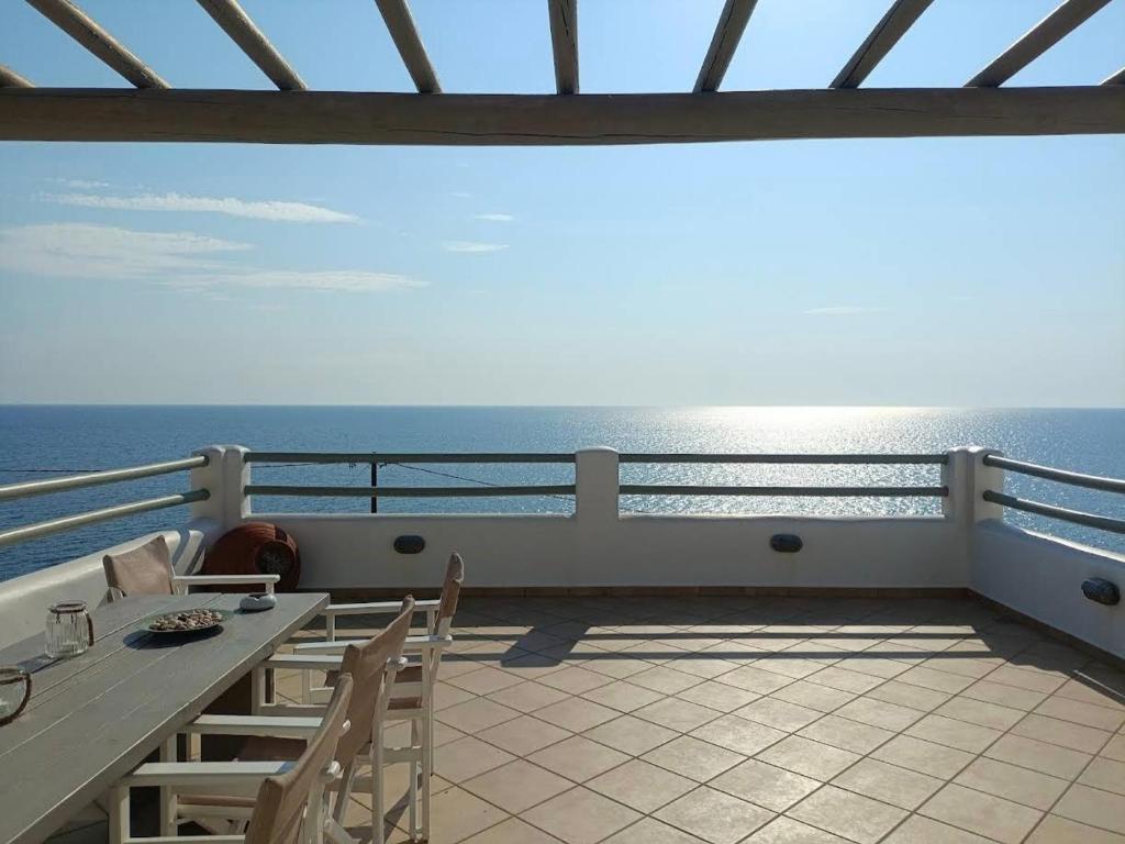a balcony with a table and chairs and the ocean at Plori House in Skiros