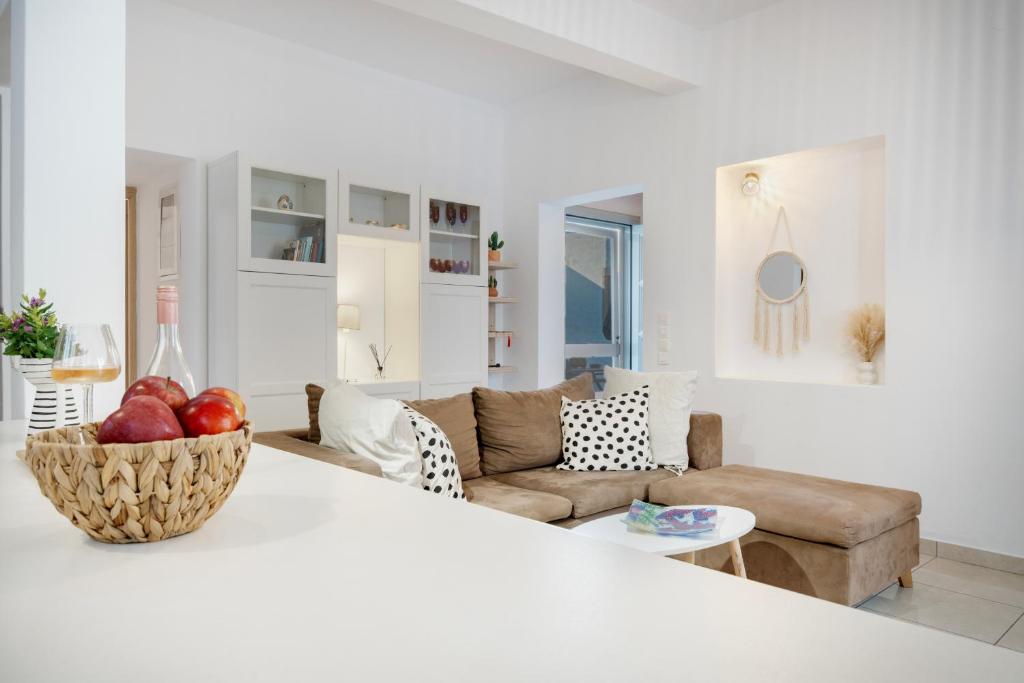 a white living room with a couch and a bowl of fruit at Consolato House in Patmos