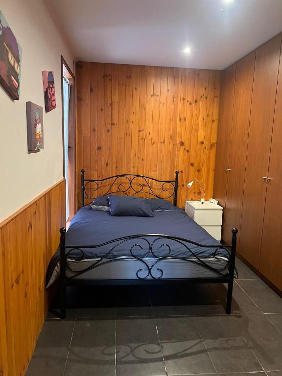 a bedroom with a bed with a wooden wall at Villa Ouro Verde in Gondomar