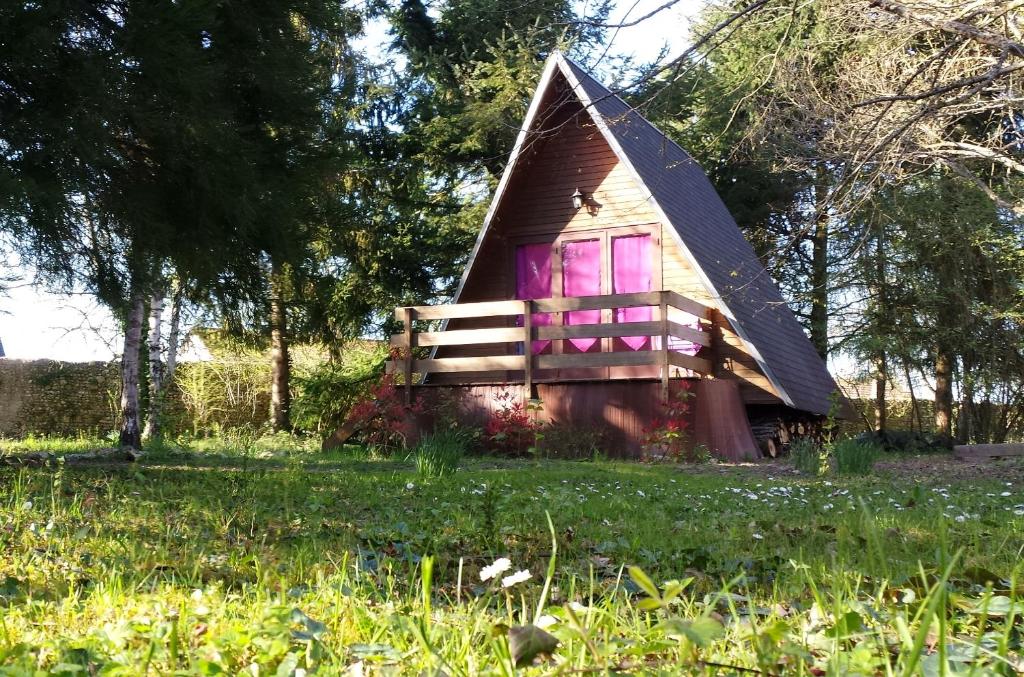 a small house with a pointed roof and pink windows at La Rossignolerie - Cabane aux oiseaux in Chouzy-sur-Cisse