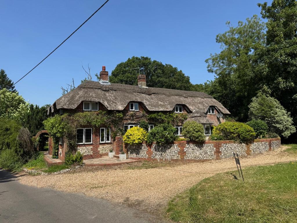 an old stone house with ivy growing on it at 3 Bedrooms, 3 Double Beds, 6 Guests, Countryside Thatched Cottage in Four Marks