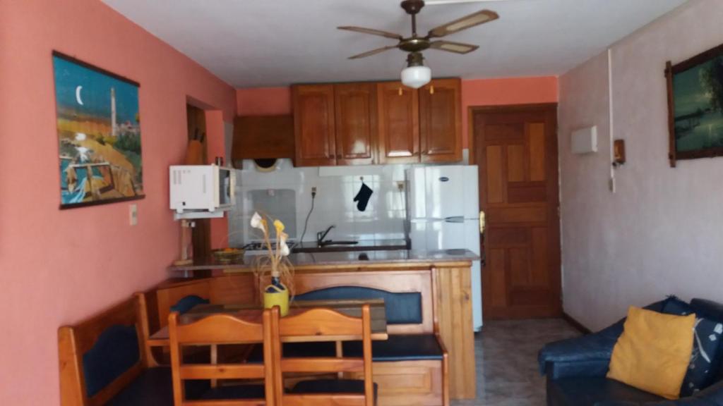 a kitchen with a table and a white refrigerator at Apartamento La balconada in La Paloma