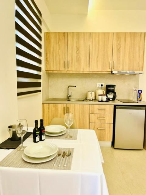 a kitchen with a table with plates and wine glasses at Georges Estates Hotel in Stoupa