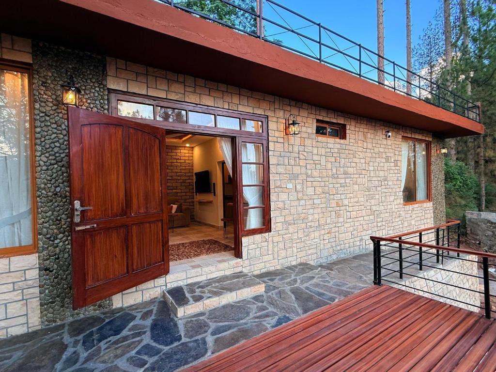 a house with a wooden door and a deck at Highland by Gunner Lodges in Patriata