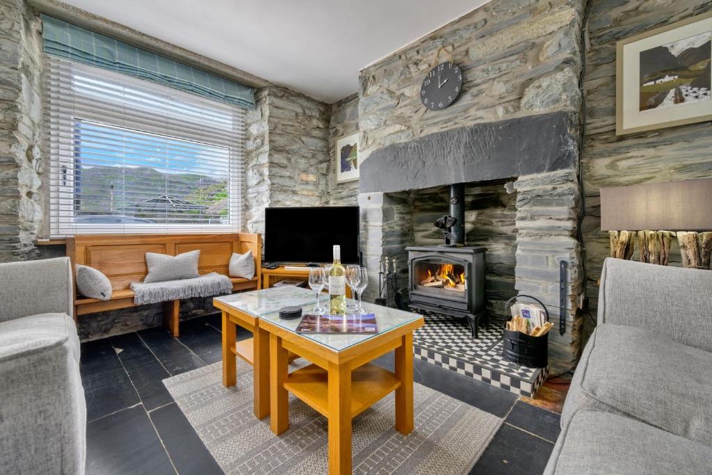 a living room with a stone wall at Finest Retreats - Garreg Ddu in Blaenau-Ffestiniog