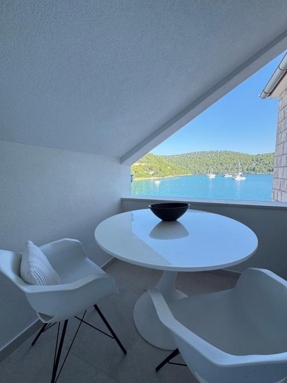 a white table and chairs in a room with a large window at Adriatic Retreat Mljet in Polače