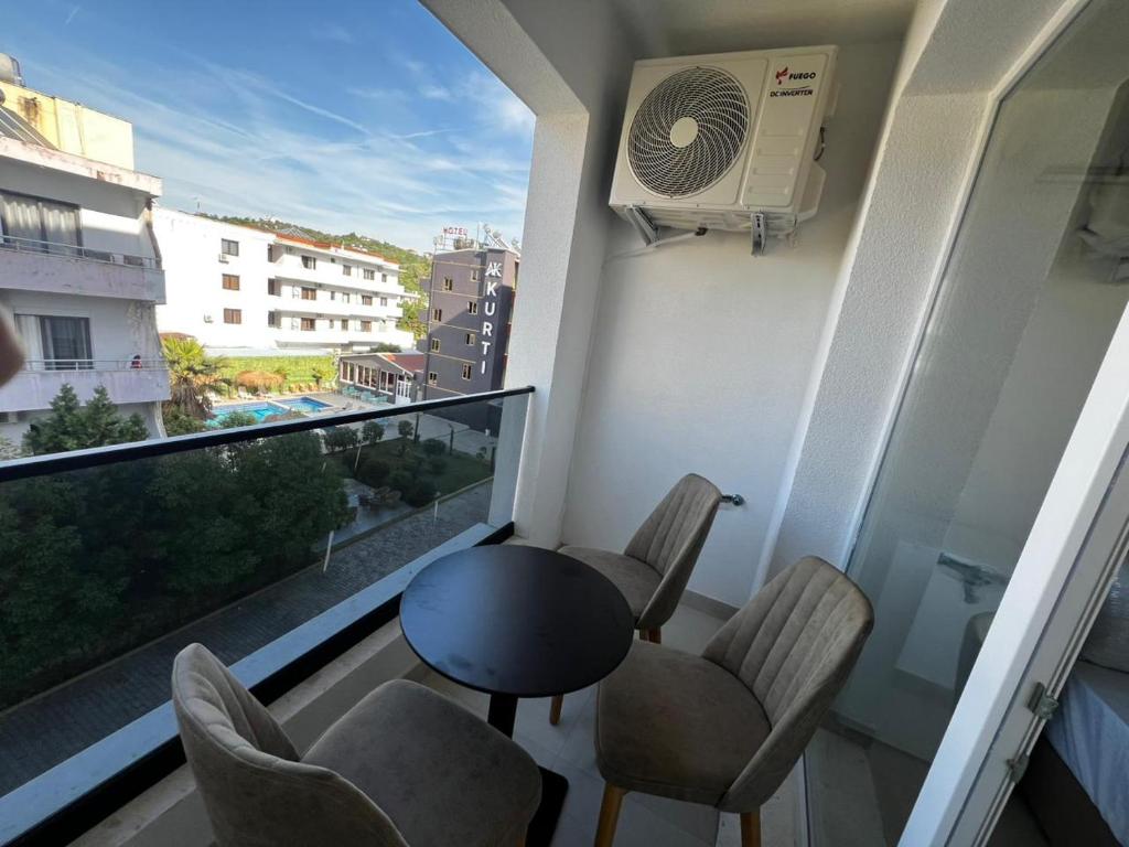 a balcony with a table and chairs and a large window at f & xh apartaments in Kavajë