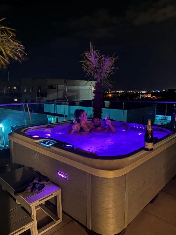 a woman and child in a hot tub at night at Penthouse Rico in Eforie Nord