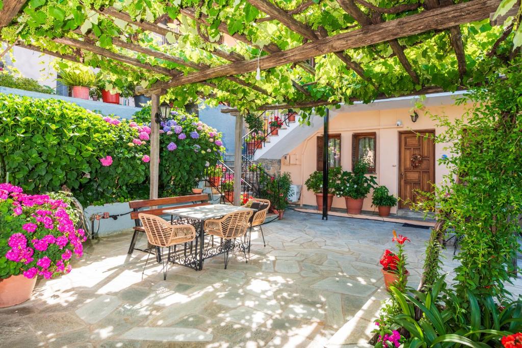 a patio with a table and chairs and flowers at Adilon in Tsagarada