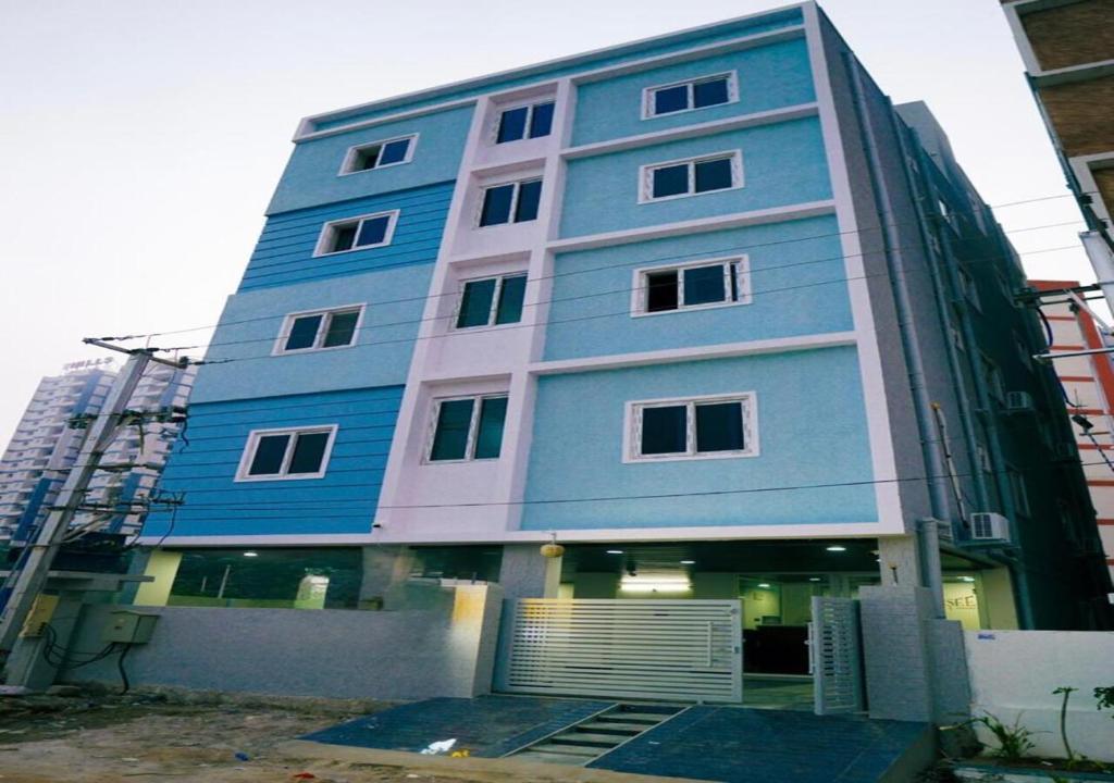 a blue building with a gate in front of it at NRI Hotels & Coliving in Hyderabad