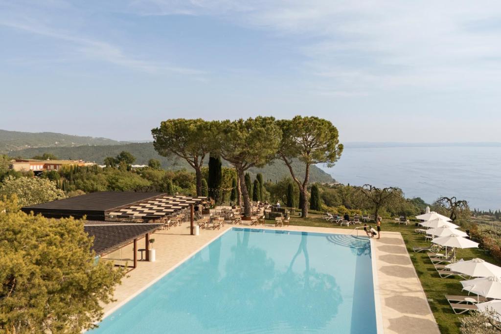 a view of a swimming pool with chairs and umbrellas at Residence San Michele in Costermano