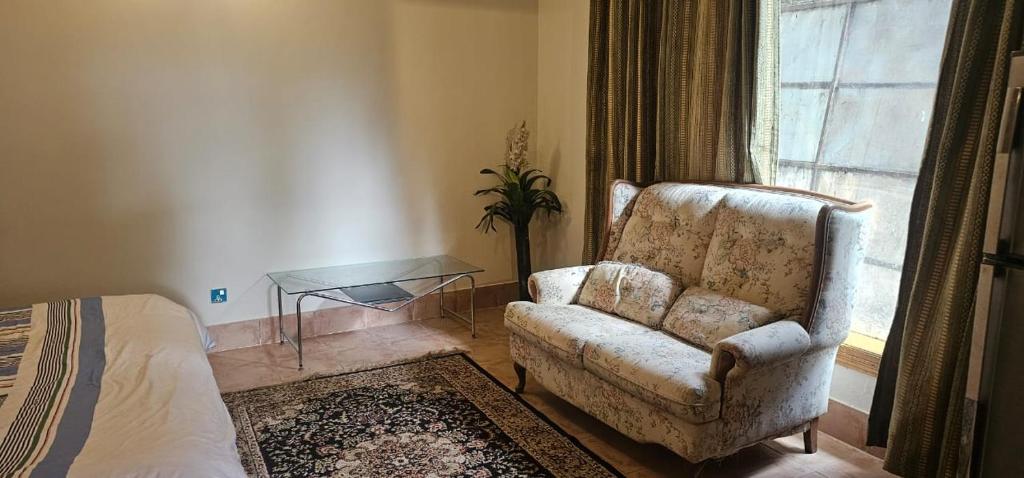 a living room with a chair and a window at Green's Cottage in Nathia Gali