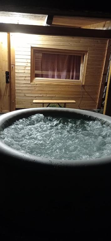 a bath tub filled with water in a room at Zlatibor Koliba Laki in Zlatibor