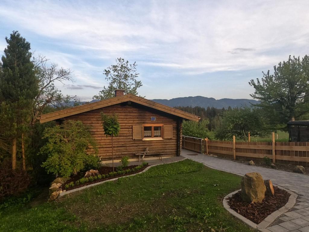 a log cabin in a yard with a fence at Blockhaus Hipp in Steingaden
