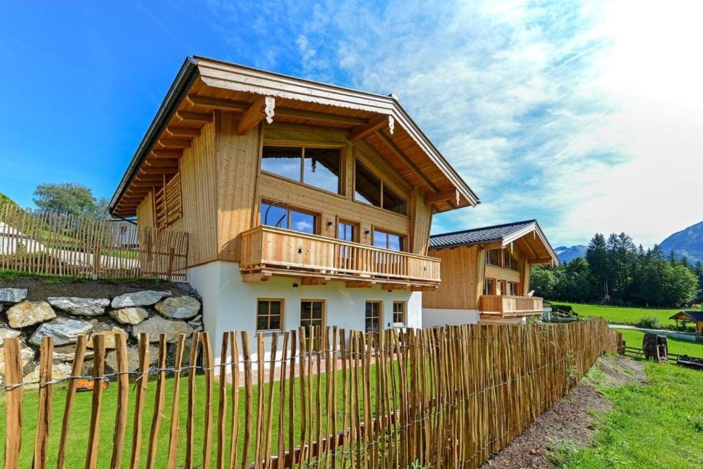 a house with a wooden fence in front of it at Gams Lodge 2 in Weng