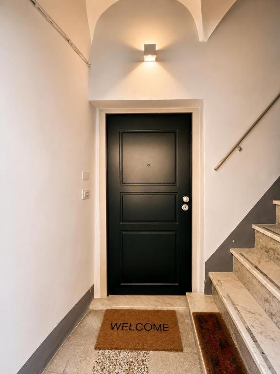 a black door with a welcome mat in front of it at Domus Tarquinia in Tarquinia