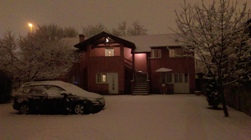 a car parked in front of a house covered in snow at Guest House Lucija in Zagreb