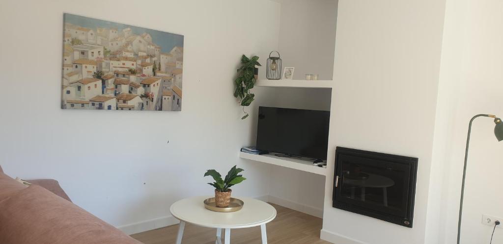 a living room with a couch and a tv and a table at Tía Pepa in El Gastor