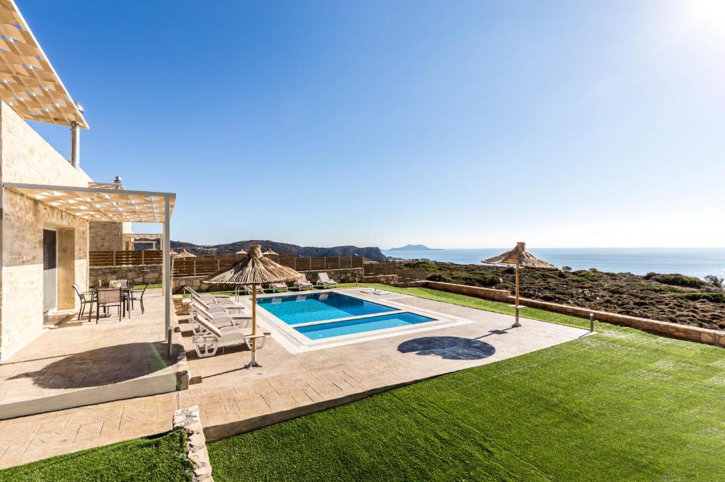 a house with a swimming pool and a patio at Villa Thea in Triopetra