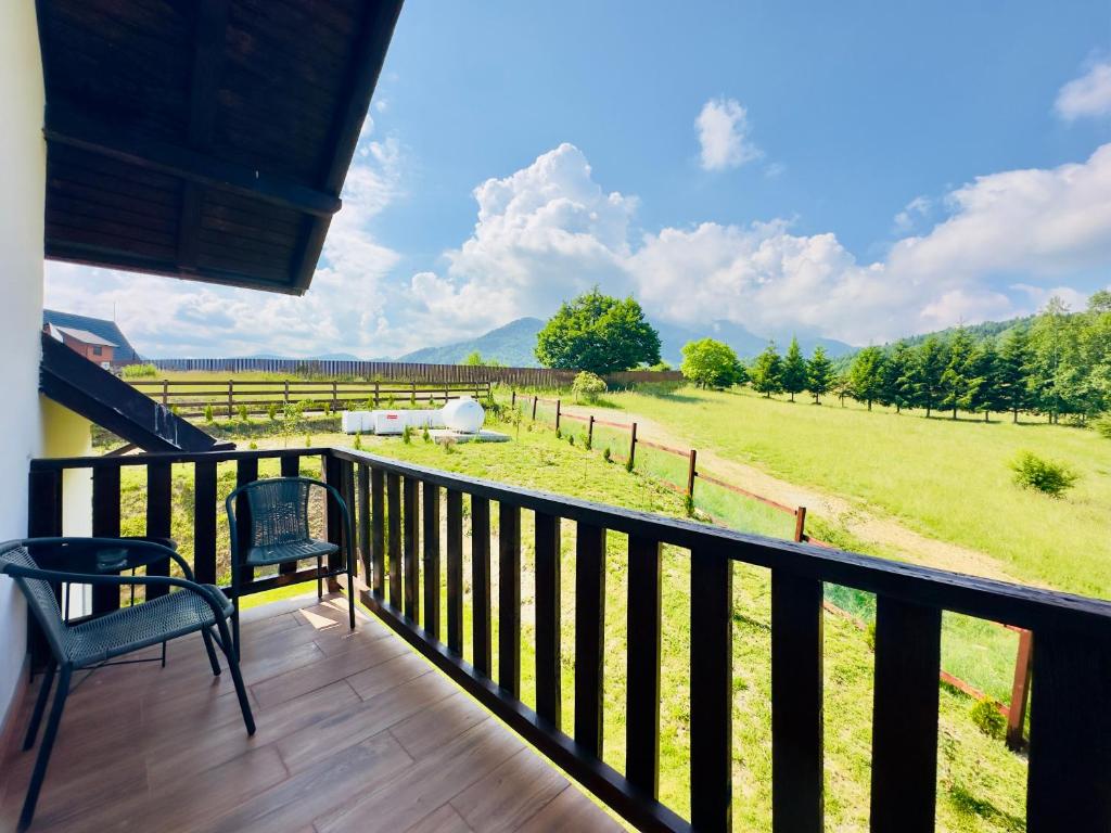 a balcony with a view of a farm field at Travelers Nest by Casa Calatorului in Râşnov