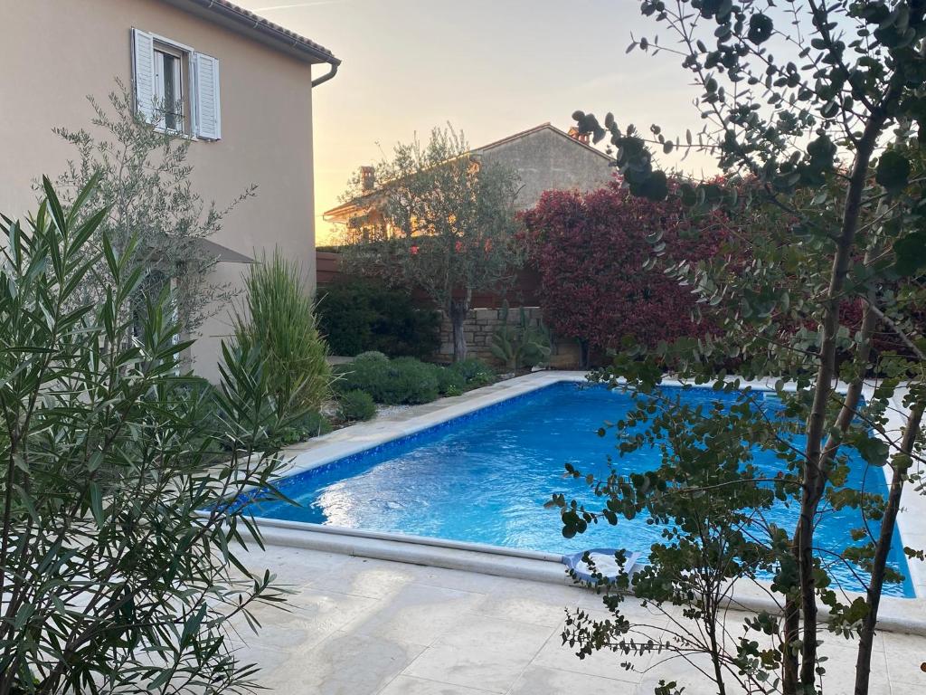 a swimming pool in a yard next to a house at Villa Vin - Pool, ruhig, strandnah, Klimaanlage, Außenküche, Meeresnähe, Gästebetreuer in Babići