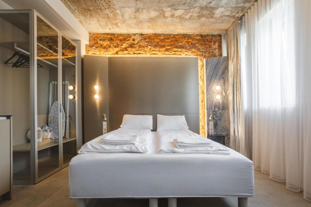 a bedroom with a white bed in a room at Resume apartments in Kaunas