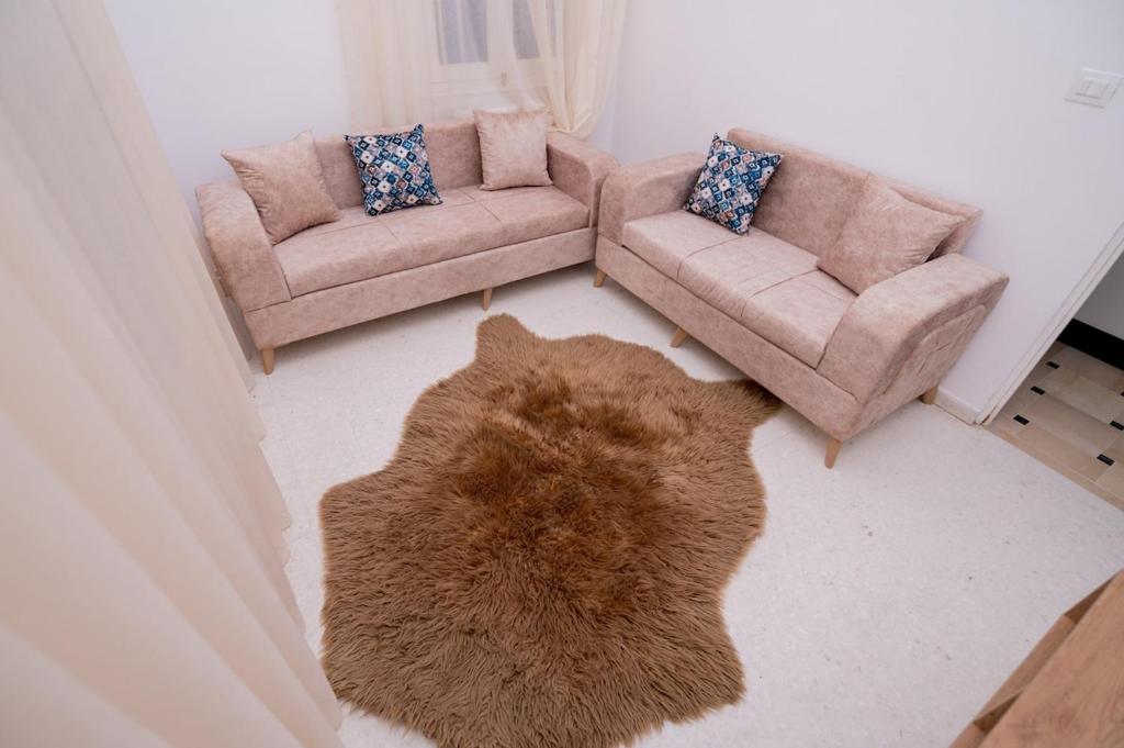 a living room with two couches and a rug at VILLA Lafayette in Tunis