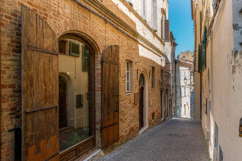 an empty alley in an old city with buildings at Hotel Oviv - La dimora del Borgo in Acquaviva Picena
