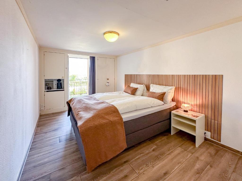 a bedroom with a large bed with a wooden headboard at Hotel Du Lac in Därligen