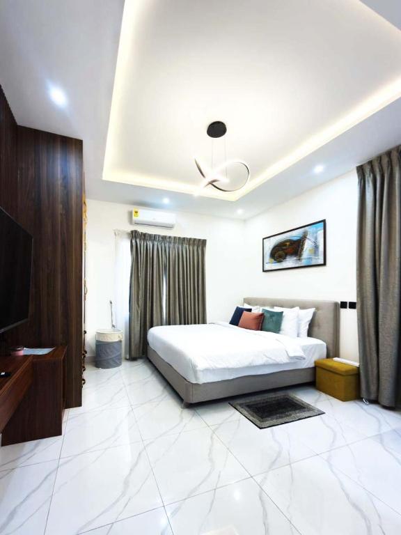 a bedroom with a bed and a television in it at Executive Cozy Suite at THE HIDDEN DOMUS I Saltpond Suite in Madina