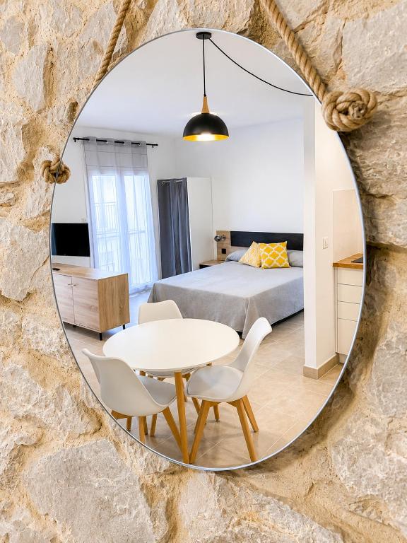 a bedroom with a bed and a table in a mirror at Apartaments l'Escala Centre in L'Escala