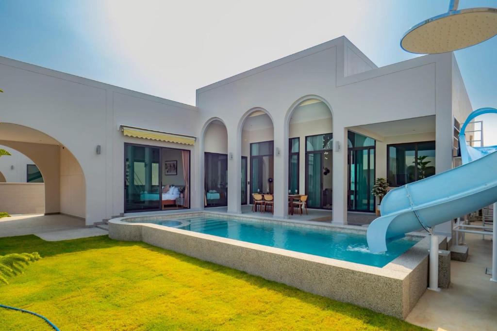 a pool in a house with a water slide at April Pool Day Villa Cha-am in Cha Am