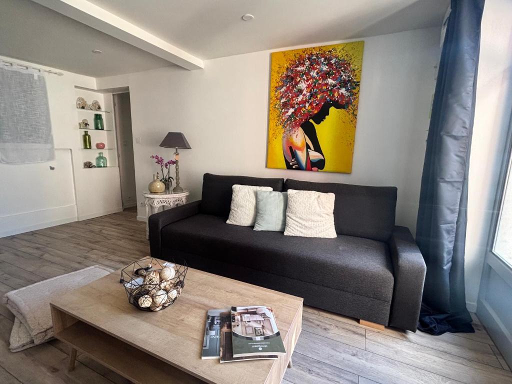 a living room with a couch and a painting on the wall at Petite halte à Volnay in Volnay