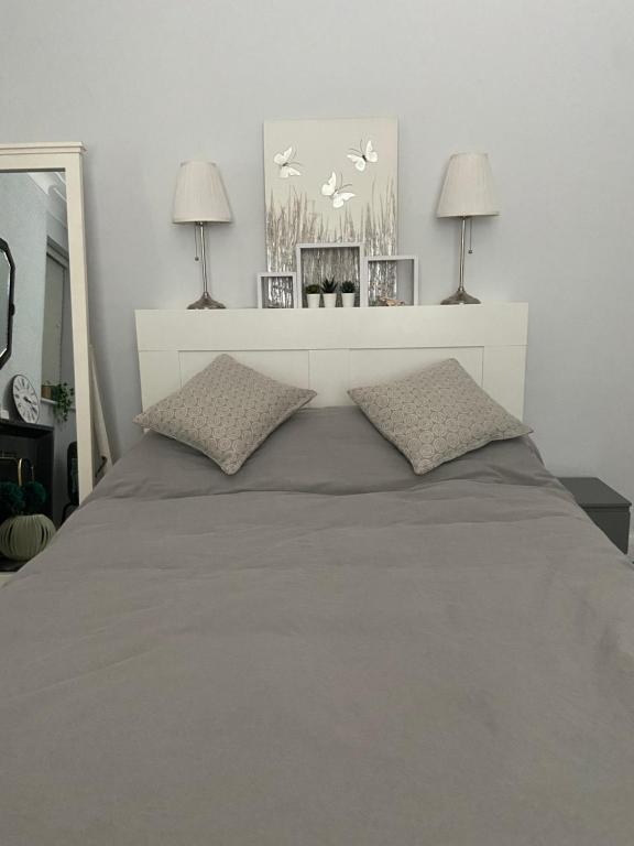 a bedroom with a large bed with two lamps at Spacious Double Studio-style room in Orpington
