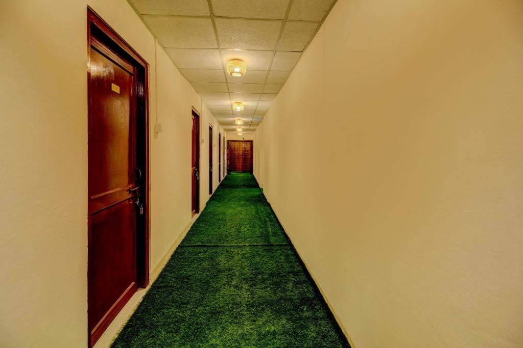an empty hallway with green carpet in a corridor at SPOT ON Rainbow Lodge in Guwahati