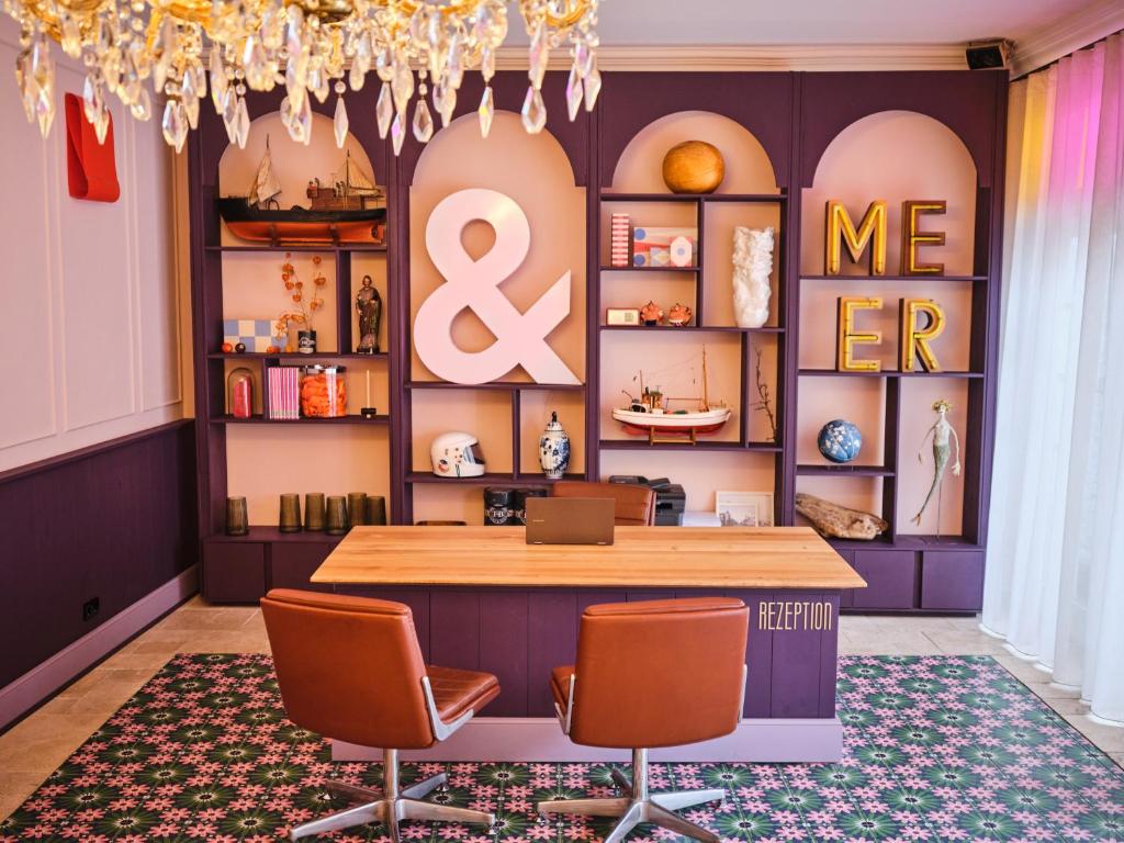 a room with a table and two chairs and a shelf at freustil Hotel in Binz